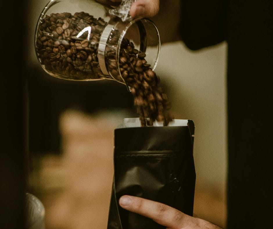 pouring coffee beans into a bag for purchase